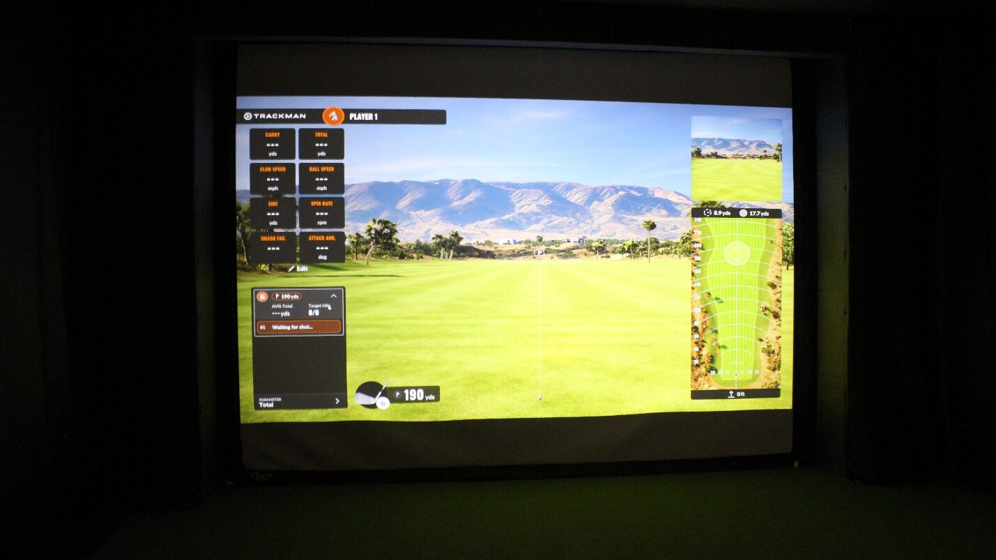 A Trackman golf simulator screen in the bay, fairway on the display and ready for the first shot.