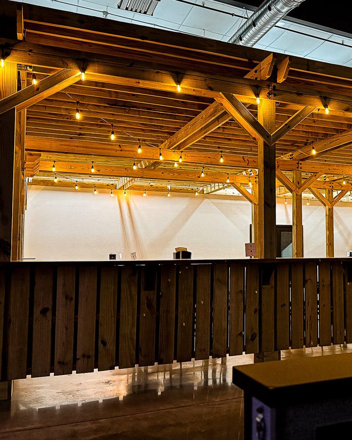 Inside the pergola at night, string lights glowing along the timber beams.